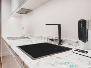 eine Küche mit Spüle und Arbeitsplatte in der Unterkunft Orion House - Luxury Apartment overlooking Milford Marina, Pembrokeshire in Milford Haven + 15 Fotos