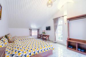 a bedroom with a bed and a table with chairs at Lovely House in Da Lat