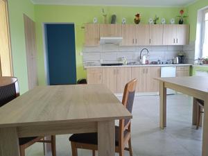 een keuken met een houten tafel en stoelen in een kamer bij Agrostok noclegi agroturystyka in Strzelce Górne