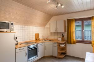 a kitchen with white cabinets and a microwave at Familienwohnung Haus 18 in Überlingen