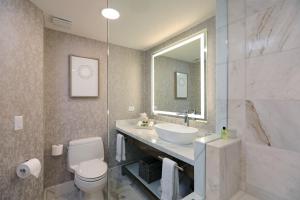 een badkamer met een wastafel, een toilet en een spiegel bij InterContinental Costa Rica at Multiplaza Mall, an IHG Hotel in San José