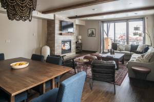 a living room with a table and a couch and a fireplace at Mountain Lake Condo - Unit 401B in Big Sky