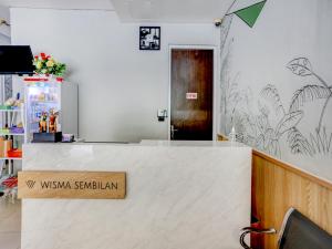 een lobby met een balie met een bord erop bij SUPER OYO Capital O 90056 Wisma Kebon Kacang 9 in Jakarta