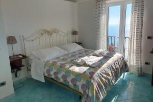 a bedroom with a bed with a view of the ocean at Villa Casola B&B in Positano