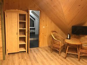 a room with a table and chairs and a television at Писанка Плюс in Yaremche