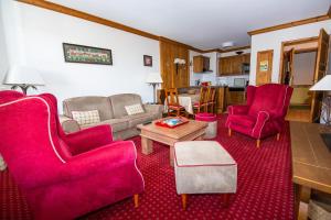 a living room with red chairs and a couch and a table at Appartement au centre du village ARC1950, 2 ou 4 personnes in Arc 1950