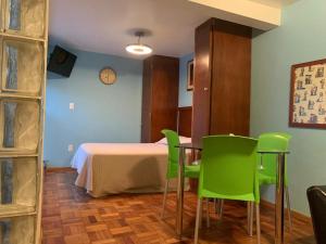 a room with a table and green chairs at Monoambientes Cuauhtemoc in Mexico City