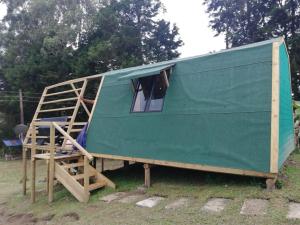 une remorque verte avec une échelle dans un champ dans l'établissement Hotel Campestre El Refugio de Balsora, à Filandia