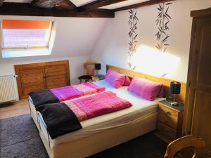 - une chambre dotée d'un lit avec des oreillers roses dans l'établissement Gasthaus Korfu, à Edenkoben