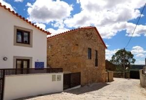 a white house with a fence in front of it at Casas do Torreão 3 casas de alojamento local in Alfaiates
