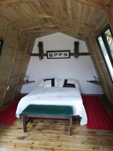 a bedroom with a white bed in a attic at Hotel Campestre El Refugio de Balsora in Filandia