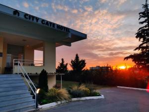 ein City Gate Hotel mit Sonnenuntergang im Hintergrund in der Unterkunft City Gate Hotel Airport Thessaloniki in Thessaloniki
