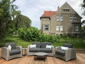 eine Terrasse mit Stühlen, einem Tisch und einem Haus in der Unterkunft Villa 32 Kröpelin in Kröpelin