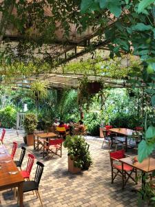 un patio esterno con tavoli, sedie e piante di Rukka Lodge a Tumbaco