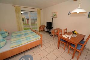 a bedroom with a bed and a table and chairs at Hof Brinker - Kornspeicher in Boiensdorf