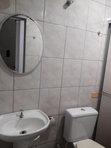 a bathroom with a toilet and a sink and a mirror at Unihotel in Hortolândia