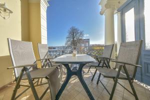 una mesa y sillas en un balcón con vistas en Villa Seeschloss 10, en Heringsdorf