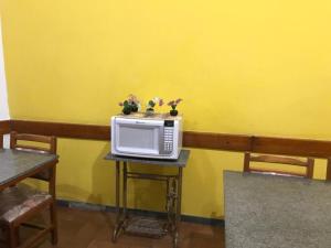 a microwave sitting on a table with flowers on it at Unihotel in Hortolândia