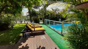 a row of benches sitting next to a swimming pool at Pousada Palhocinha Garopaba in Garopaba +41 photos