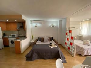 een kleine kamer met een bed en een keuken bij Studio Orquídea Beach 4 in Fuengirola