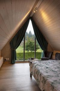 a bedroom with a bed and a large window at Bosgasten in Putten