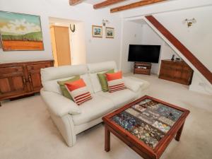 a living room with a white couch and a coffee table at 1A Chantry Place in Morpeth