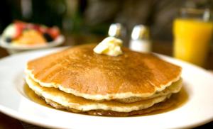 a stack of pancakes with butter on a plate at Holiday Inn San Diego Bayside, an IHG Hotel in San Diego