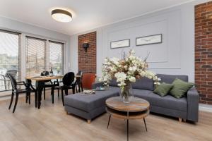 - un salon avec un canapé et une table dans l'établissement Exclusive Apartments Mostowa by Renters Prestige, à Poznań