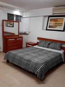 een slaapkamer met een zwart-wit bed en een dressoir bij Suite- Studio- Zimmer in Bet Sheʼan