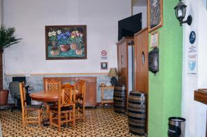 a dining room with a table and chairs and a painting at Hotel Colonial in Aguascalientes
