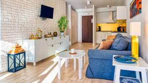 Il comprend un salon avec un canapé bleu et une cuisine. dans l'établissement Apartament Triventi 48 Premium SPA - 5D Apartamenty, à Karpacz