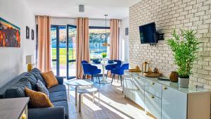 - un salon avec un canapé et une table avec des chaises dans l'établissement Apartament Triventi 48 Premium SPA - 5D Apartamenty, à Karpacz