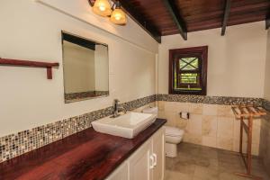 a bathroom with a sink and a toilet at Santosha Barbados in Saint Andrew