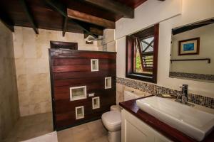 a bathroom with a sink and a toilet and a shower at Santosha Barbados in Saint Andrew