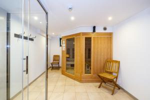 Habitación con silla y puerta de cristal en Luxueuse et spacieuse villa avec sauna et piscine, en Malmedy