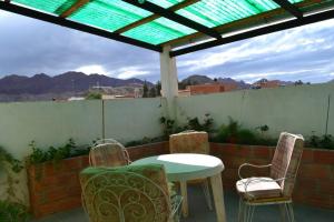 a table and chairs on a patio with a roof at Hotel La Torre in Tupiza