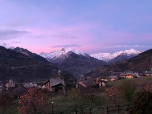 uma vista para uma serra com montanhas cobertas de neve em Affittacamere Verger Plein Soleil em Saint-Pierre