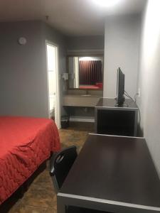 sypialnia z łóżkiem i biurkiem z telewizorem w obiekcie RED CROWN INN w mieście Dallas
