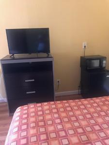 a bedroom with a bed and a desk with a television at RED CROWN INN in Dallas