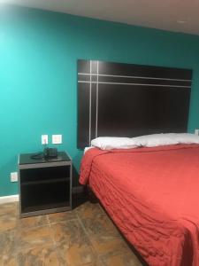 a bedroom with a red bed and a green wall at RED CROWN INN in Dallas