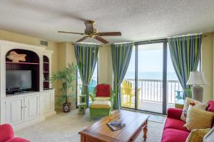 a living room with a ceiling fan and a television at 320 COV - Relaxing Oceanfront Villa - Unbeatable Views in Folly Beach