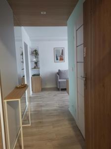 a room with a hallway with a table and a couch at Apartament uTymka in Słupsk