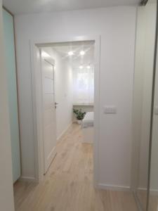 a white room with a door leading to a bedroom at Apartament uTymka in Słupsk