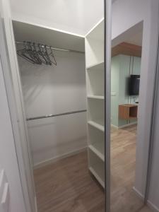 a walk in closet with a glass door at Apartament uTymka in Słupsk