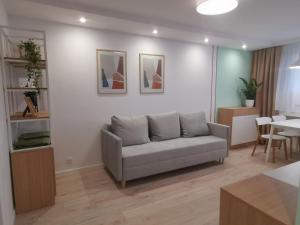 a living room with a couch and a table at Apartament uTymka in Słupsk