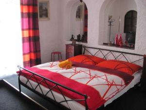 a bedroom with a bed with red and white sheets at Penzion Muraty in Ostrava