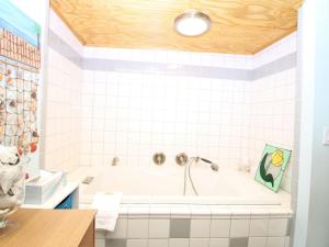 a white bathroom with a tub with a wooden ceiling at E Huron 401 in Folly Beach +15 photos