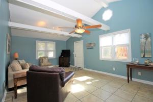 a living room with a ceiling fan and a couch at Salty Shack Unit C - Salty Shack - Dog Friendly Home - Across from the Beach - Central Location! in Folly Beach