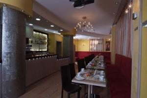 a dining room with a long table and a bar at Hotel Cristal Eboli in Eboli