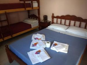 a bedroom with two beds with towels on the bed at Hostal Portal del Valle in Cafayate